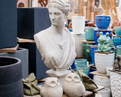 statue greco-style statue bust of a woman next to two small abstract owl statues